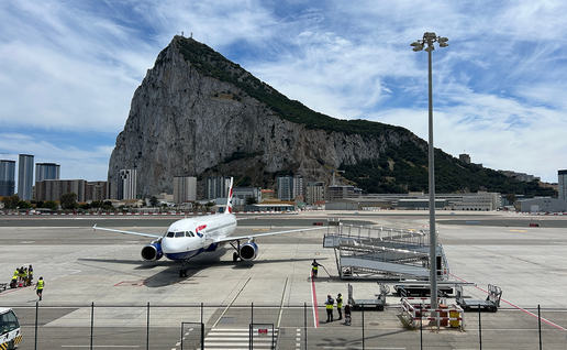 Aircraft on runway at Gibraltar airport with rock in the background.