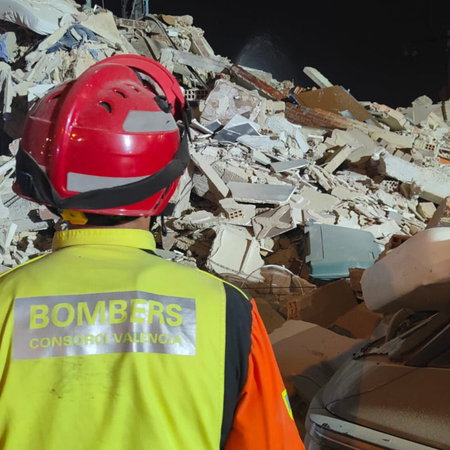 Firefighter inspects building collapse.
