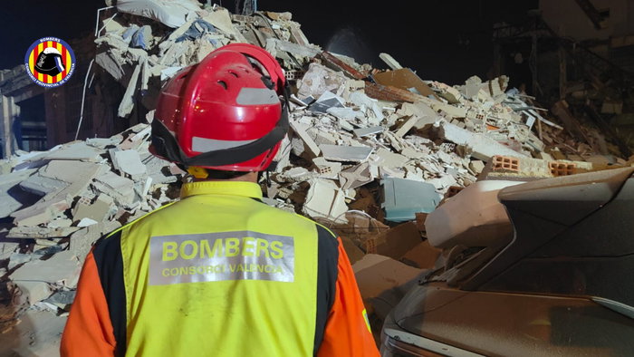 Firefighter inspects building collapse.