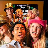 Group of young people taking a selfie photo with party hats