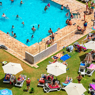 Busy hotel pool with people on sunbeds