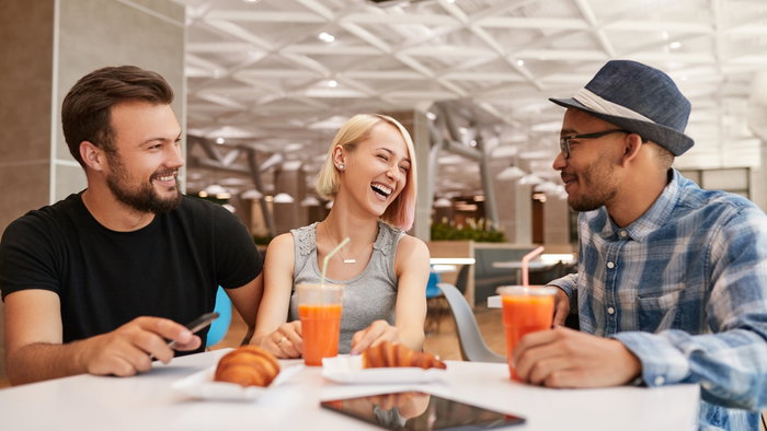 Group of friendly multi-ethnic young people meeting at airport relaxed and chatting
