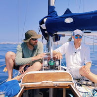 Two scientists on board a sailing vessel with a prototype underwater camera