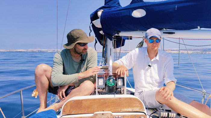Two scientists on board a sailing vessel with a prototype underwater camera