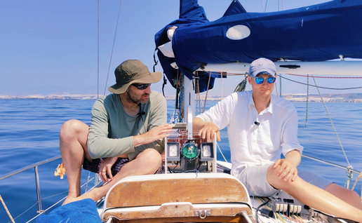 Two scientists on board a sailing vessel with a prototype underwater camera