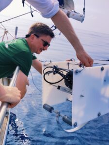 Scientist lowering a prototype camera into the sea