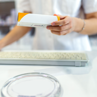 Pharmacist holding prescription medicine at a pharmacy in Spain.