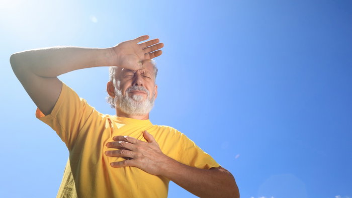 Senior man suffering from heat stroke outdoors.