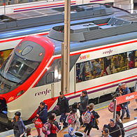 A Madrid train station platform with passengers exiting a renfe train.