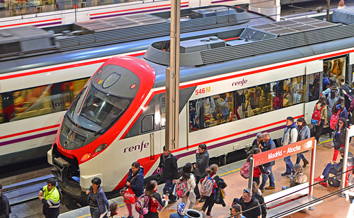 A Madrid train station platform with passengers exiting a renfe train.