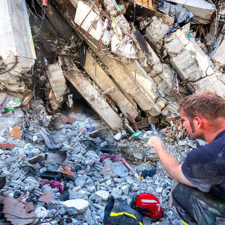 Rescue team members inspect a damaged building while searching for survivors