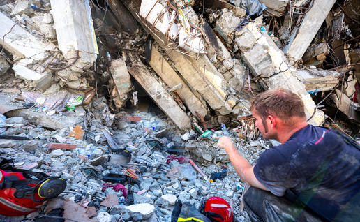 Rescue team members inspect a damaged building while searching for survivors