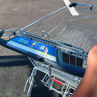 A woman holding a shopping trolley
