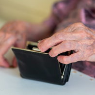 Elderly woman's hands looking through her purse