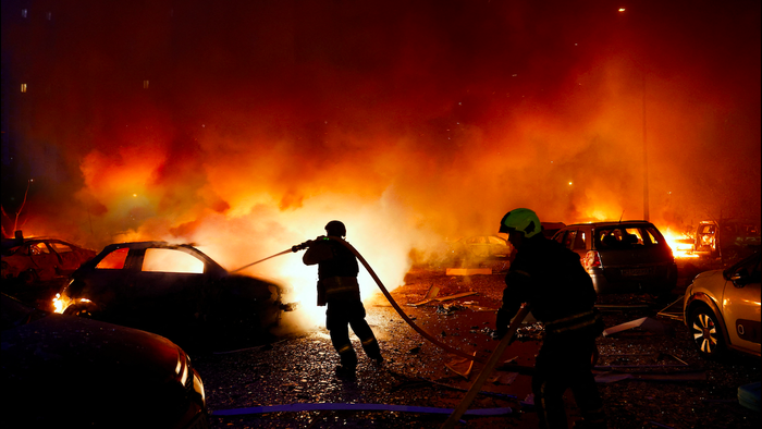 Firefighters trying to put out burning cars from a forest fire