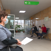 An elderly woman waiting in a waiting room to see the doctor