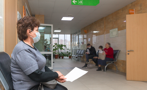 An elderly woman waiting in a waiting room to see the doctor