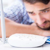 Man looking worried at his internet router.