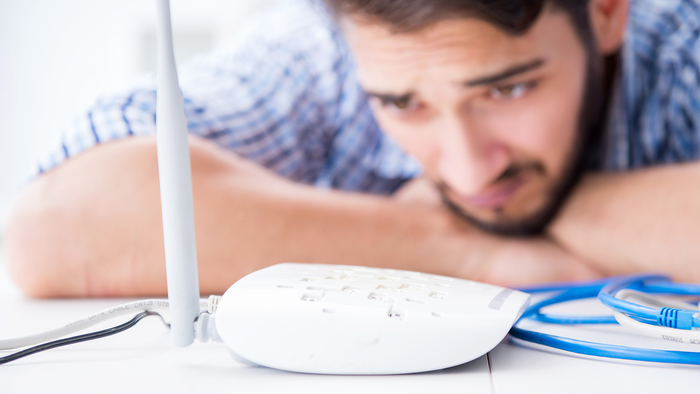 Man looking worried at his internet router.