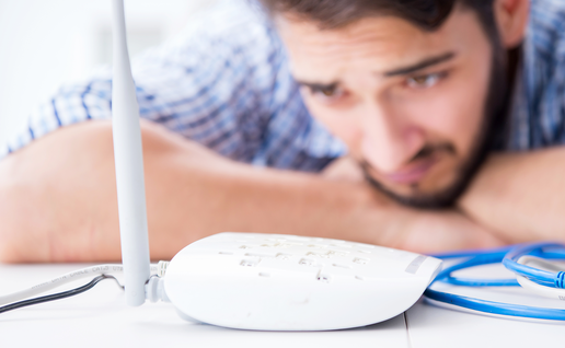 Man looking worried at his internet router.