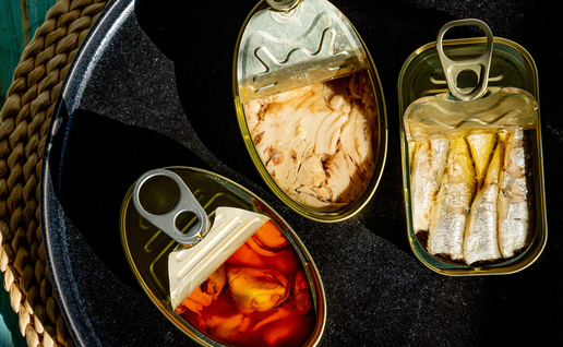 Open tins of anchovies, mussels and other gourmet seafood on a Spanish bar counter.