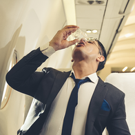 Man drinking while on a plane.