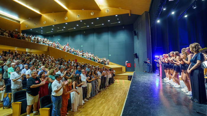 Audience members standing and applauding across the stalls and balcony inside the Auditorio Ciudad de Vera.