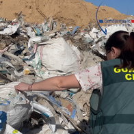 Guardia Civil officer looking through a landfill