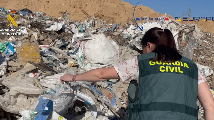 Guardia Civil officer looking through a landfill