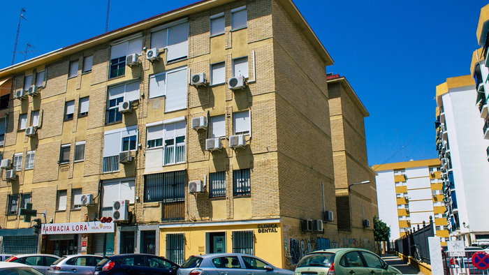 Apartment building in Spain with multiple outdoor air conditioning units mounted on the façade.