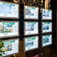 Property listings displayed in the window of a Spanish estate agency, reflecting rising house prices and strong demand across the housing market.