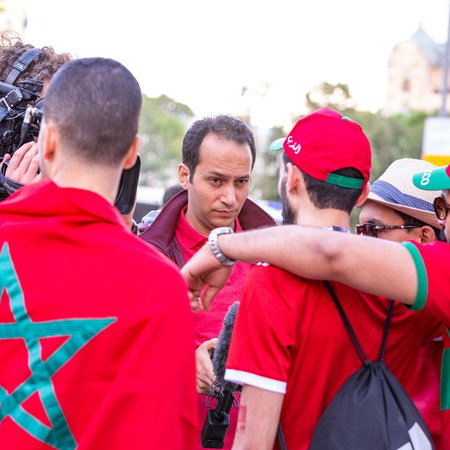 Morocco supporters wearing red shirts and a Moroccan flag during World Cup celebrations in Spain.