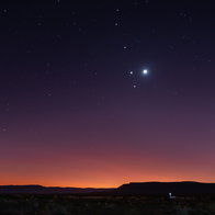 A rare planetary alignment shines above the horizon at dusk, with several bright planets visible in the night sky.
