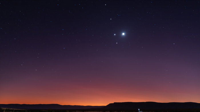 A rare planetary alignment shines above the horizon at dusk, with several bright planets visible in the night sky.