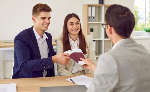 Happy couple meeting with visa manager to represent Sun Lawyers helping expats obtain their Visa in Spain