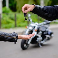 Handing over the keys to a motorbike.