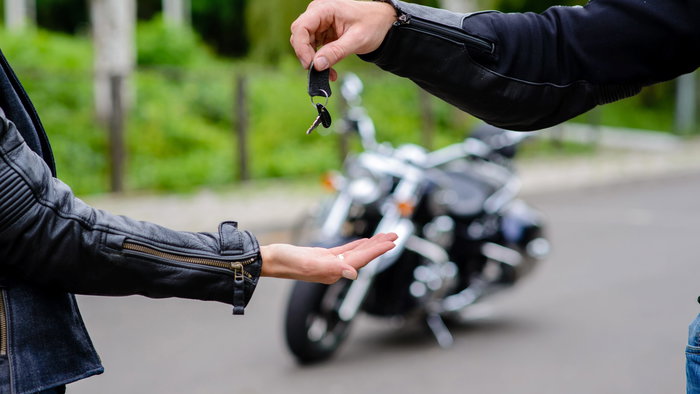 Handing over the keys to a motorbike.