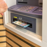 Wad of cash hangs from dispenser.