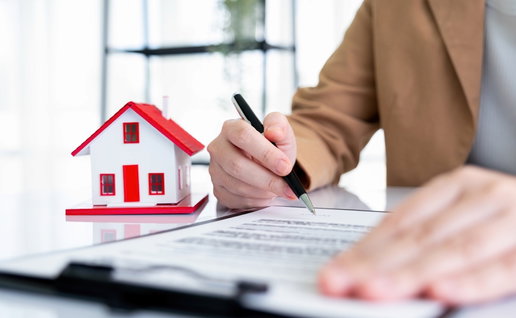 A women is finalising the sale of her house, signing paperwork.