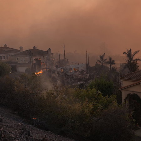Smoke filled skies and flames from a wildfire pushing through an urbanisation in Spain
