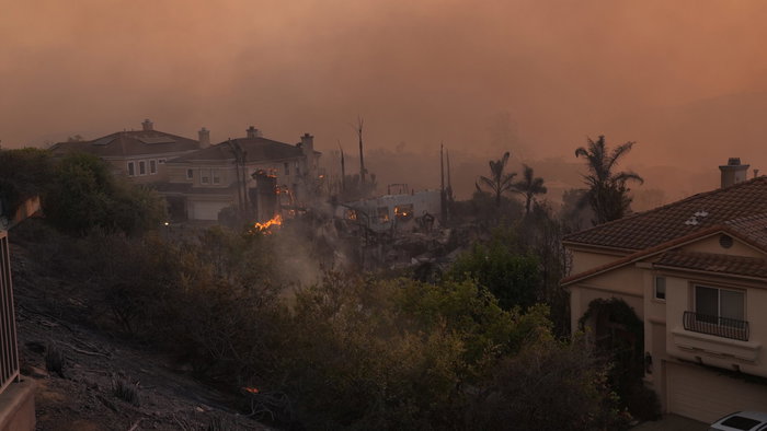 Smoke filled skies and flames from a wildfire pushing through an urbanisation in Spain