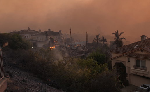 Smoke filled skies and flames from a wildfire pushing through an urbanisation in Spain