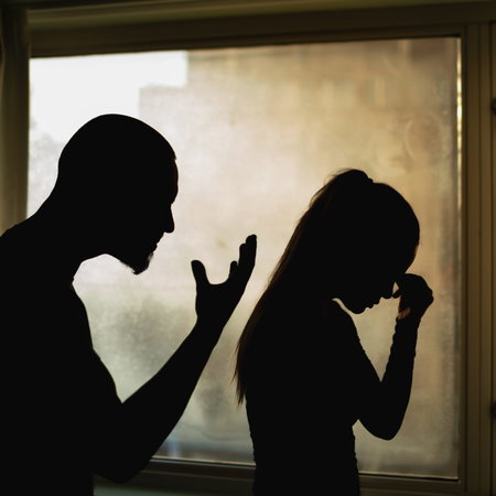 The silhouette of man yelling at a woman