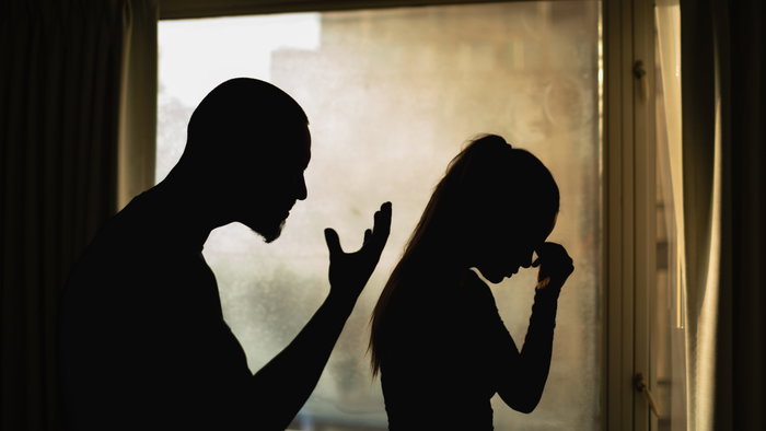 The silhouette of man yelling at a woman