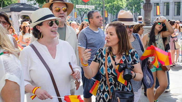 Tourists walking near Banco de España metro station in Madrid, enjoying a visit to the Spanish capital.