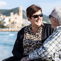Couple sitting on bench on Spanish coast.
