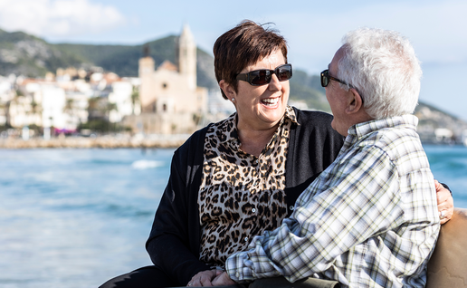 Couple sitting on bench on Spanish coast.