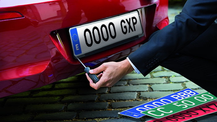A technician fits a Spanish vehicle registration plate to a newly registered car, reflecting the latest DGT number plate series introduced in July 2026.