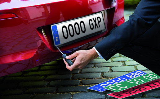 A technician fits a Spanish vehicle registration plate to a newly registered car, reflecting the latest DGT number plate series introduced in July 2026.