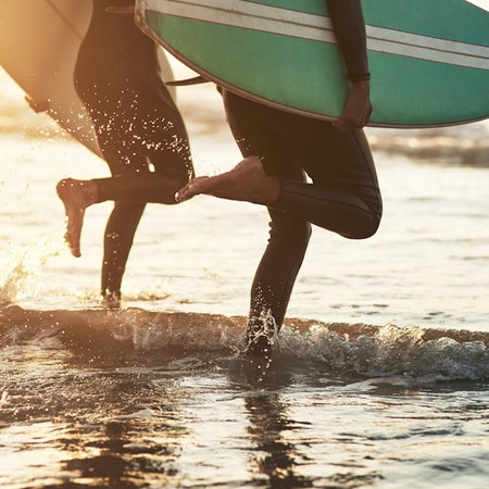 Surfers running towards the water